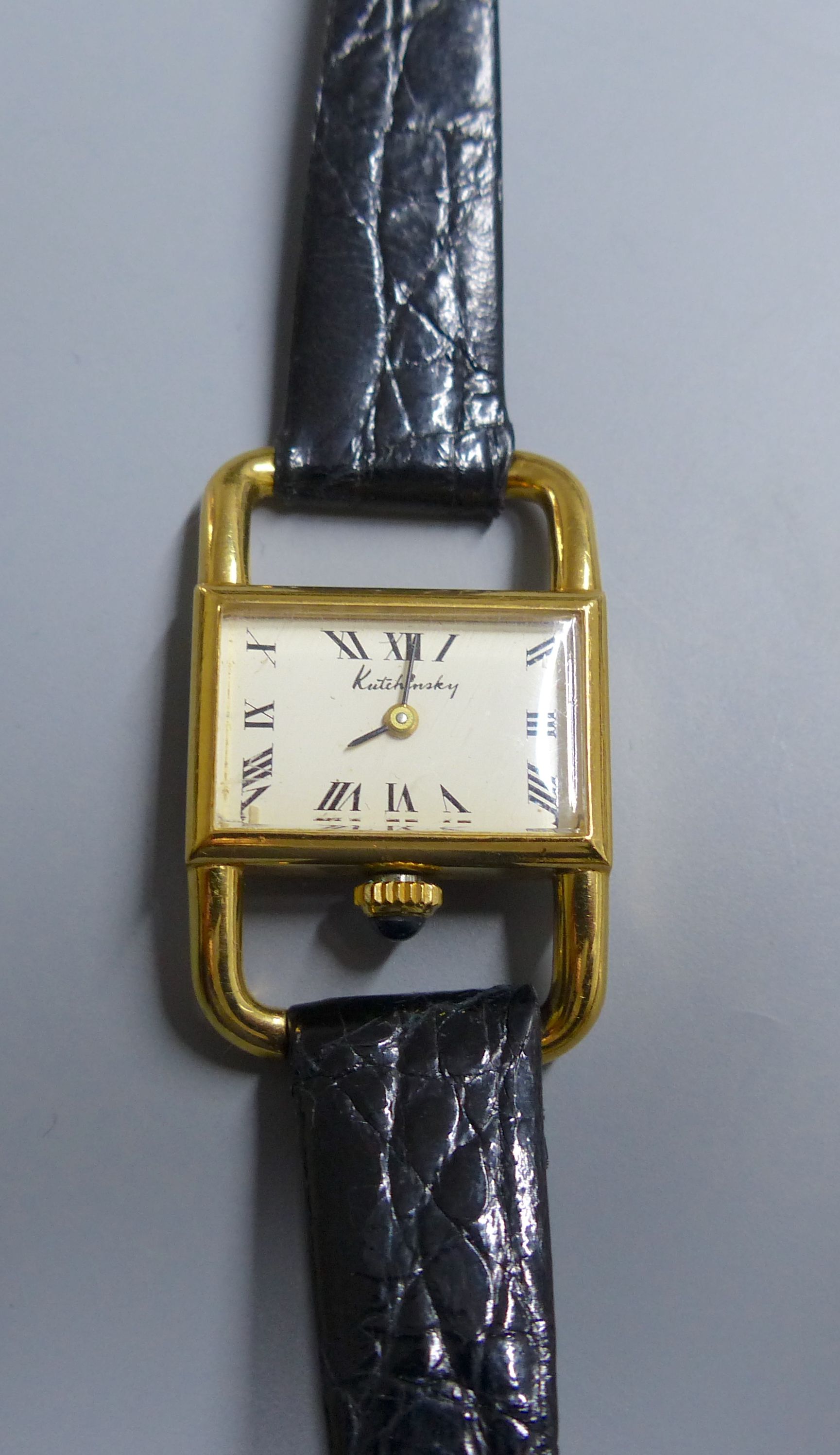A ladys 18ct gold Kutchinsky manual wind rectangular dial wrist watch, with Ebel movement, on associated leather strap,